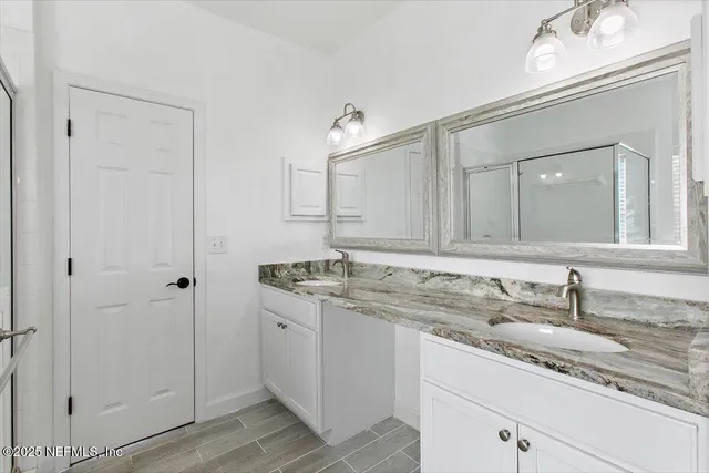 a bathroom with a granite countertop sink double and mirror