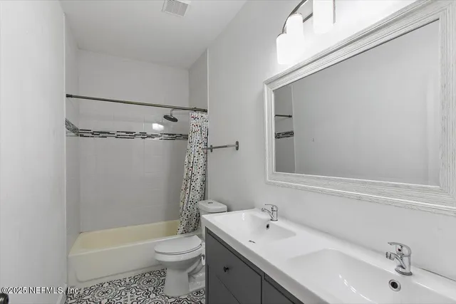 a bathroom with a sink a toilet a mirror a bathtub and shower
