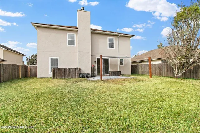 a backyard of a house with table and chairs