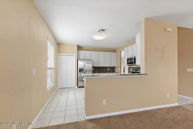 a kitchen with stainless steel appliances a refrigerator sink and microwave