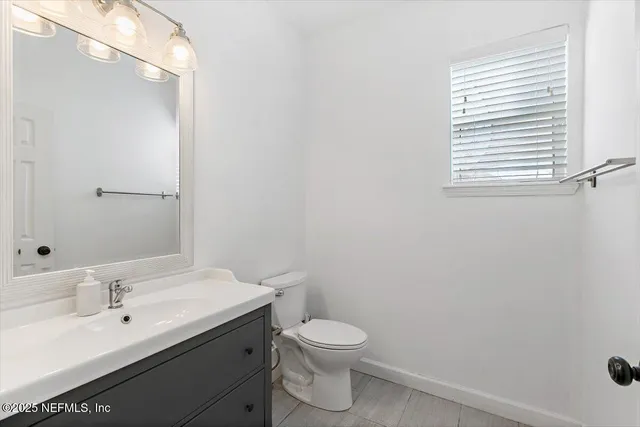 a bathroom with a sink a toilet and a mirror