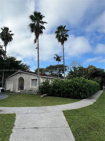 a view of a house with yard and potted plants