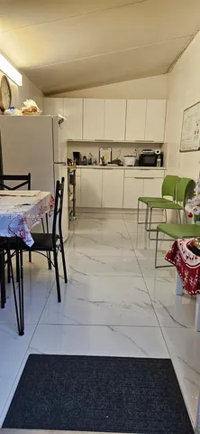 a kitchen with stainless steel appliances kitchen island granite countertop a table chairs sink and cabinets