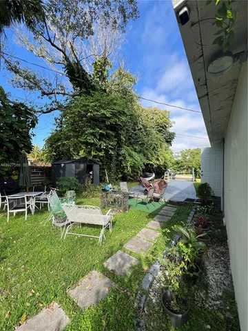 a view of a chair and table in backyard