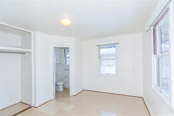 an empty room with windows and closet