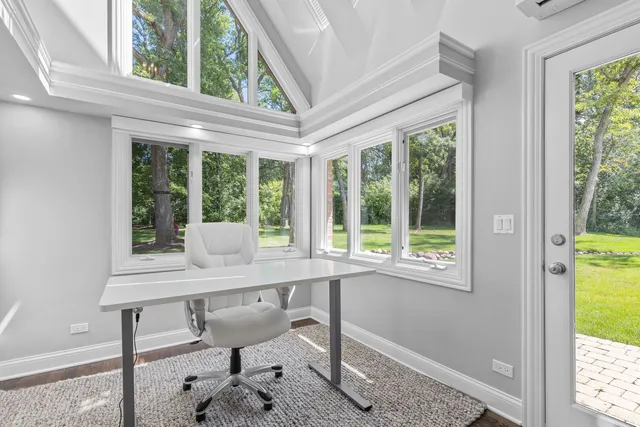 a living room with furniture a large window and wooden floor