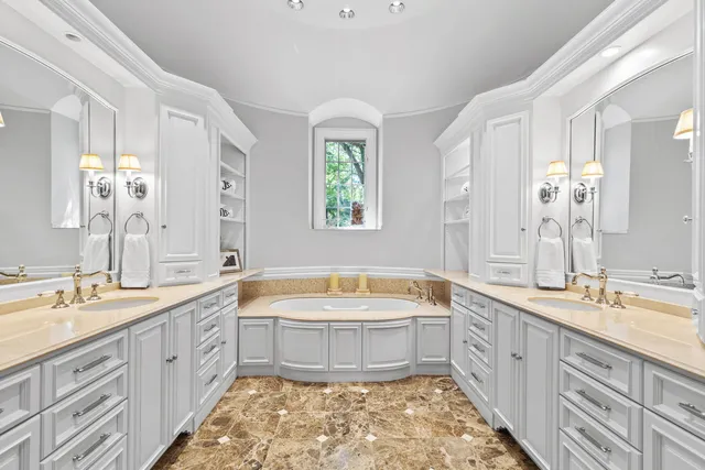 a white bed sitting in a spacious bedroom next to a window