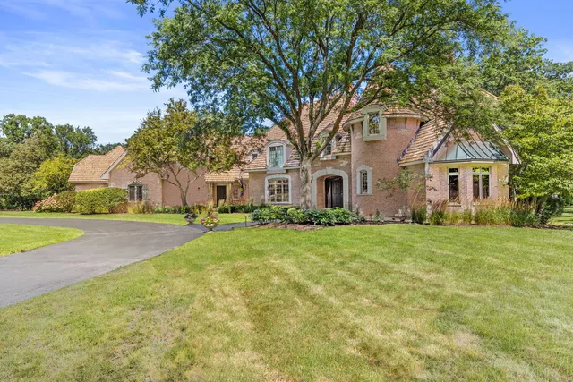 a front view of a house with yard and green space