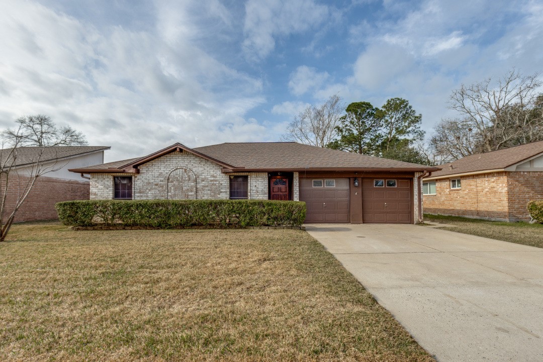 16210 Tibet Road Friendswood, TX 77546 - Photo 1 of 27 a front view of a house with a yard and garage