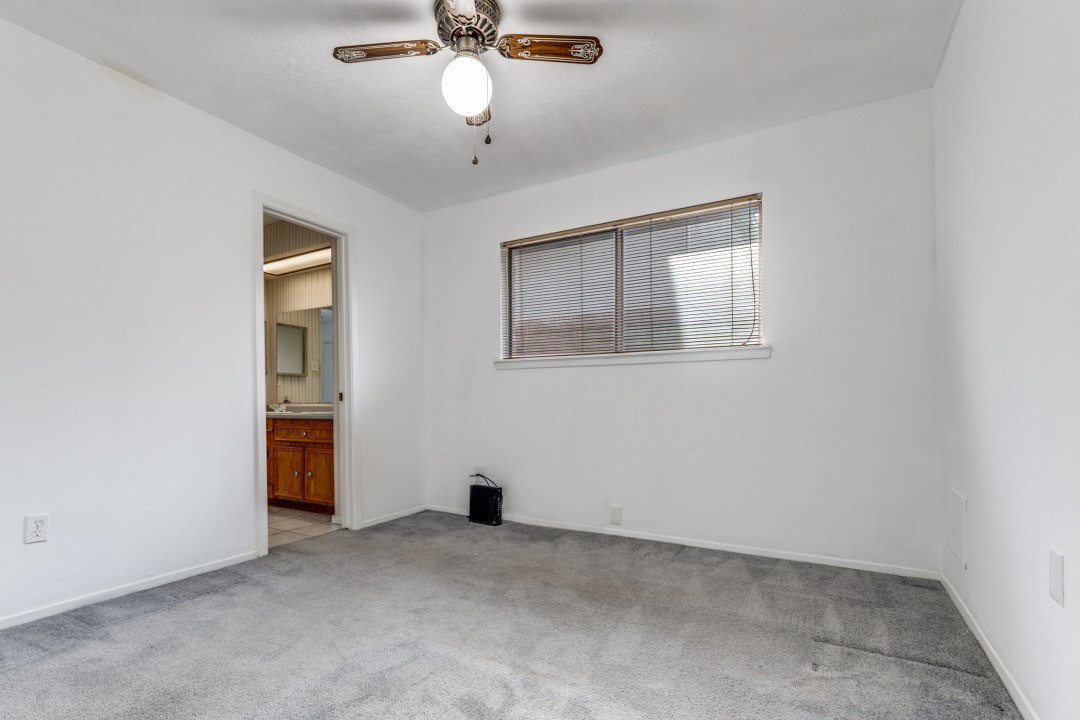 16210 Tibet Road Friendswood, TX 77546 - Photo 13 of 27 an empty room with a chandelier fan and windows