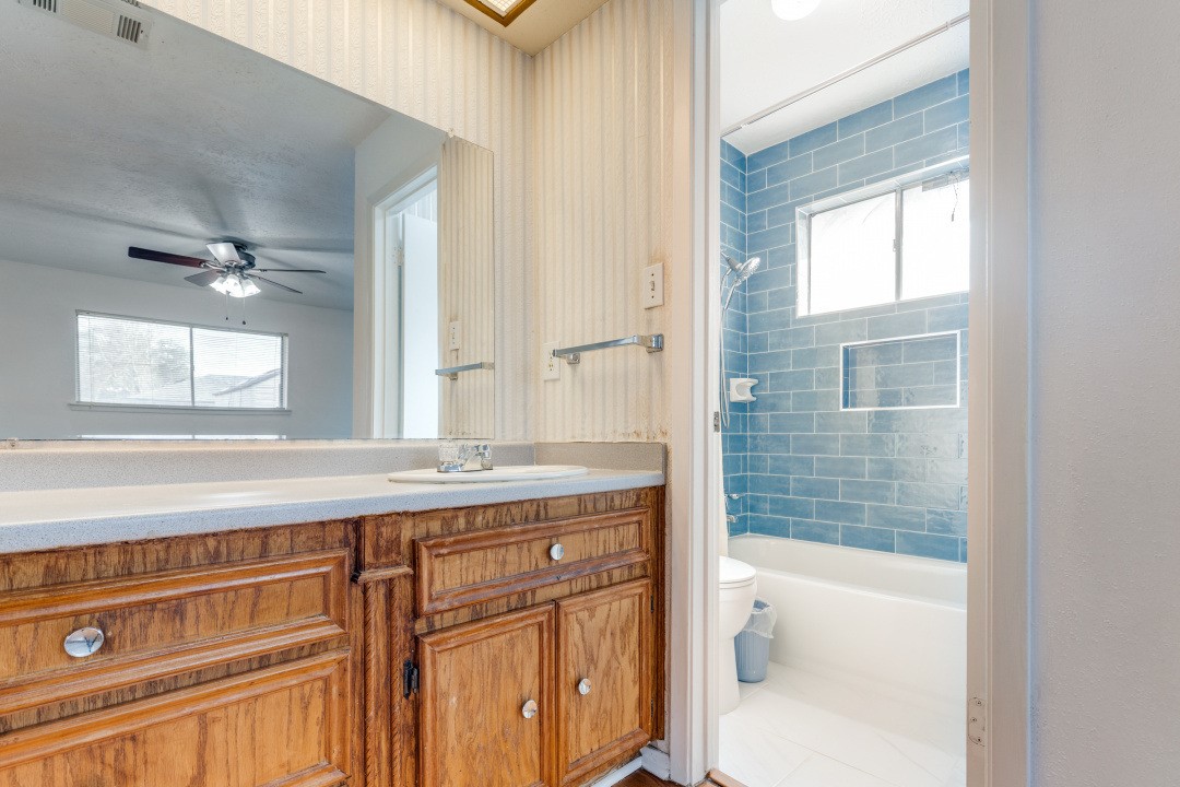16210 Tibet Road Friendswood, TX 77546 - Photo 19 of 27 a bathroom with a granite countertop sink a toilet mirror and bathtub