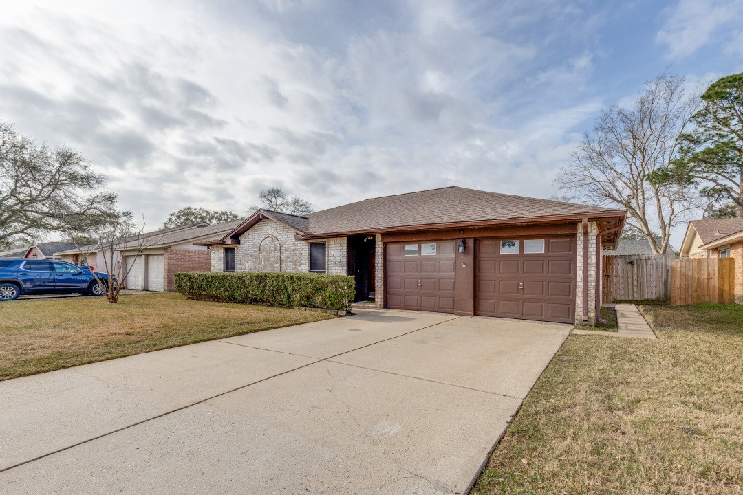 16210 Tibet Road Friendswood, TX 77546 - Photo 2 of 27 a front view of a house with a yard and garage