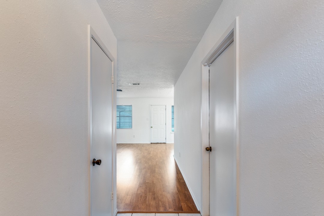 16210 Tibet Road Friendswood, TX 77546 - Photo 5 of 27 a view of a hallway with wooden floor and closet