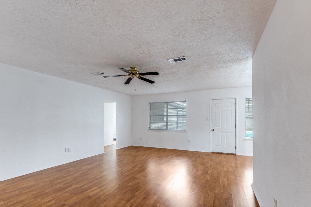 16210 Tibet Road Friendswood, TX 77546 - Photo 7 of 27 an empty room with wooden floor and windows