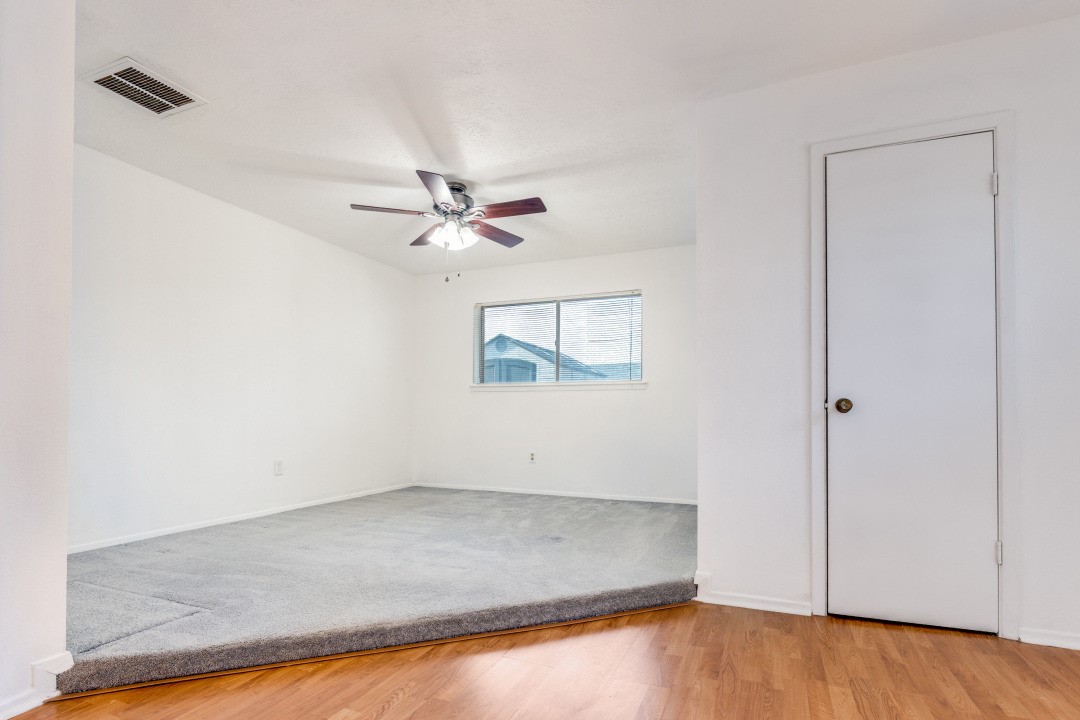 16210 Tibet Road Friendswood, TX 77546 - Photo 8 of 27 an empty room with a ceiling fan and wooden floor