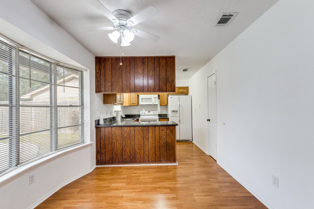 16210 Tibet Road Friendswood, TX 77546 - Photo 9 of 27 a kitchen with stainless steel appliances granite countertop a refrigerator a sink dishwasher a stove and white countertops with wooden floor