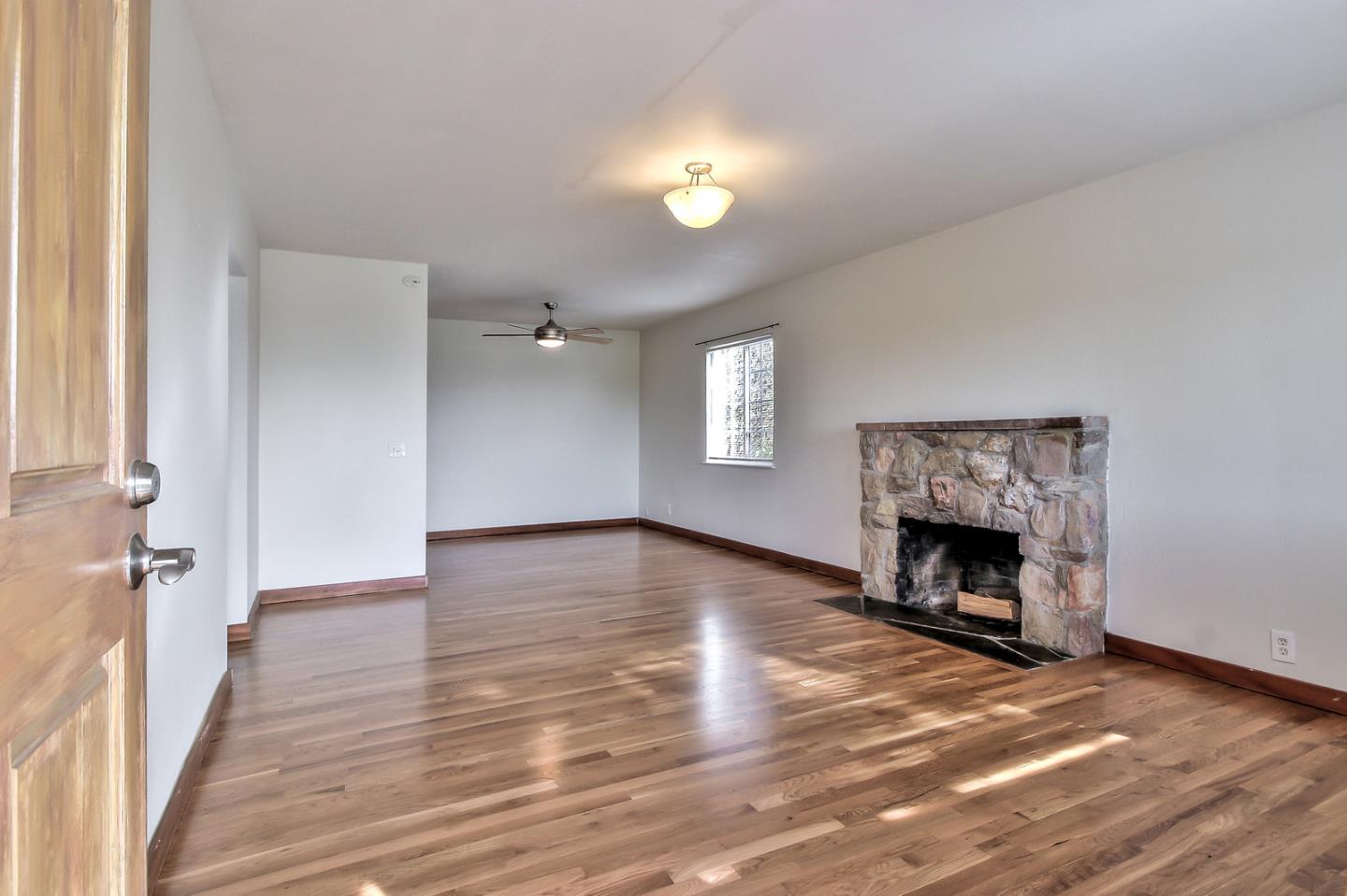 30 Heiner Road Watsonville, CA 95076 - Photo 5 of 50 a view of an empty room with wooden floor fireplace and a window