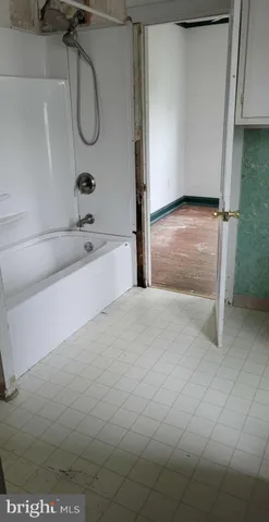 a bathroom with a tub sink a mirror and a shower