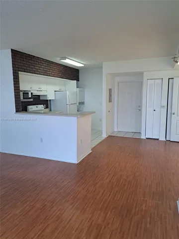 a view of a kitchen with wooden floor and electronic appliances