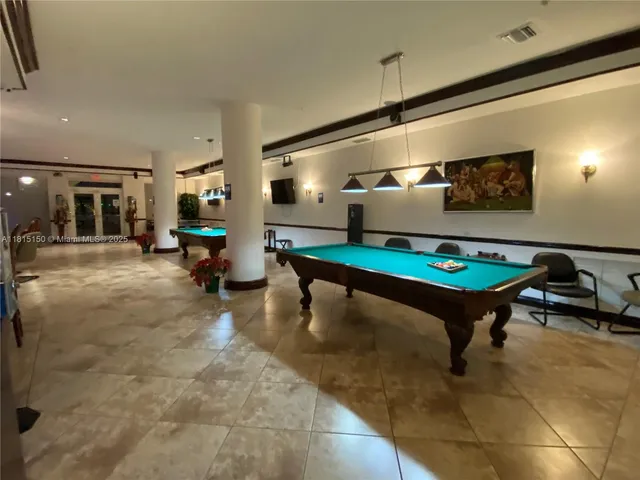 a living room with furniture pool table and chairs