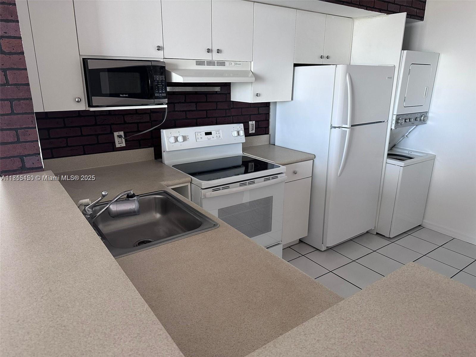 5077 Northwest 7th Street, Unit 1505 Miami, FL 33126 - Photo 7 of 30 a kitchen with a refrigerator stove and cabinets