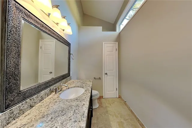 a bathroom with a granite countertop sink and a mirror