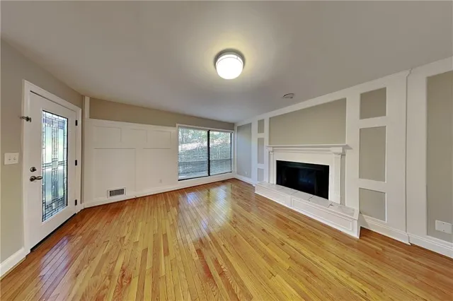 a view of empty room with wooden floor and fireplace