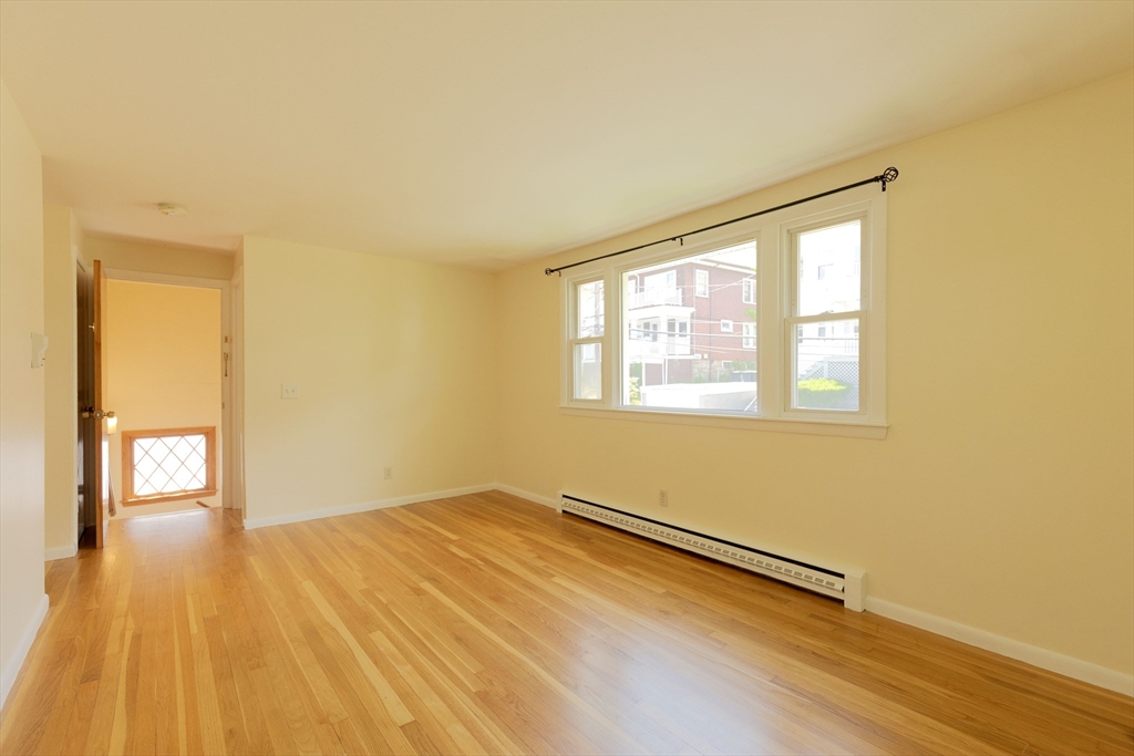 89 Brayton Road, Unit 2 Boston, MA 02135 - Photo 27 of 29 a view of an empty room with wooden floor and a window