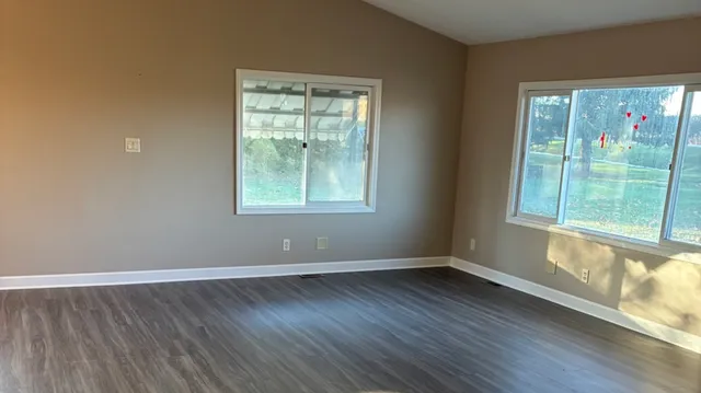 a kitchen with a sink a window and wooden floor