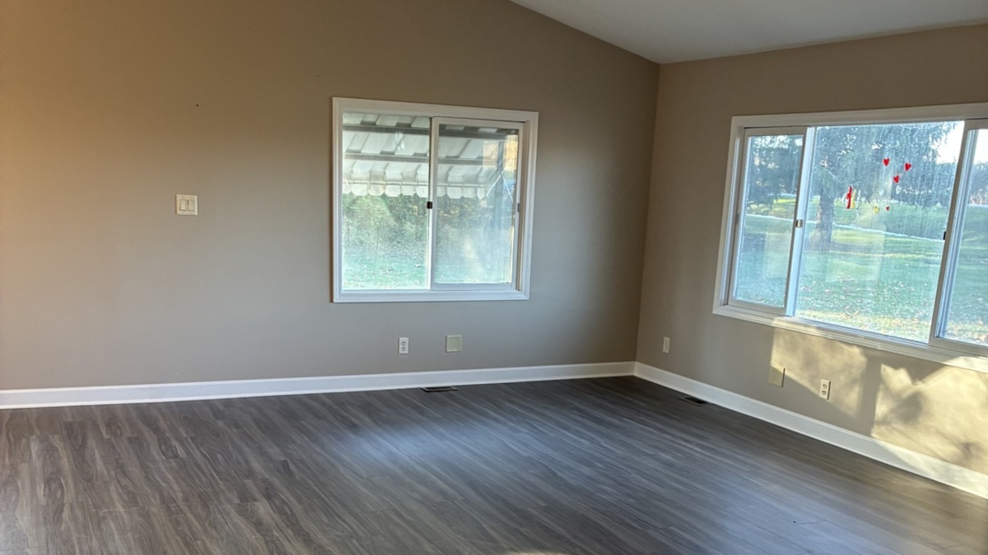 315 East Corning Road Beecher, IL 60401 - Photo 2 of 16 a view of an empty room with wooden floor and a window
