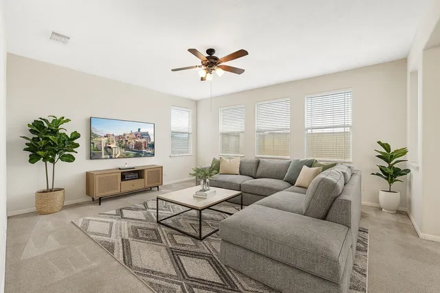 a living room with furniture a chandelier and a window