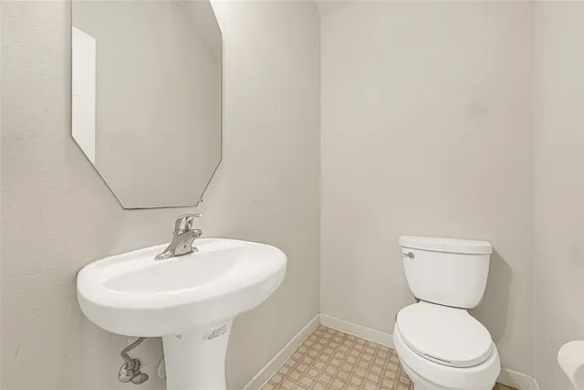 a bathroom with a sink a toilet and mirror