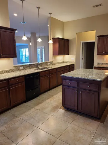 a large kitchen with kitchen island granite countertop wooden cabinets and a granite counter tops