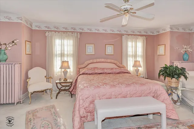 a spacious bedroom with a large bed and a chandelier