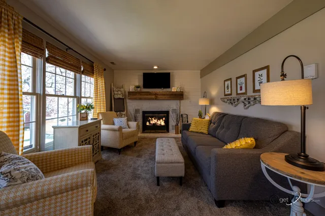 a living room with furniture fireplace and a large window