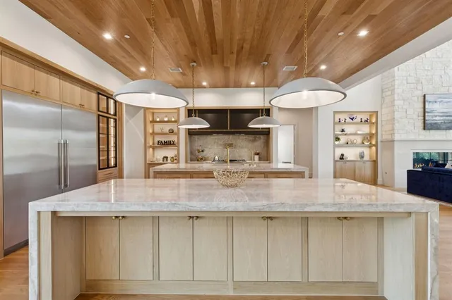 a kitchen with kitchen island a counter top a stove and a refrigerator