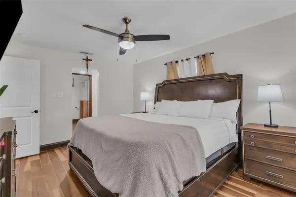 a bedroom with a bed and wooden floor