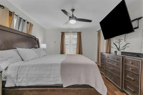 a bedroom with a large bed and a flat tv screen