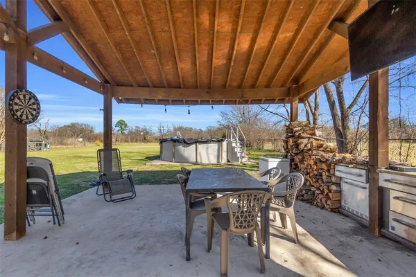 a view of a patio with a table chairs and a backyard