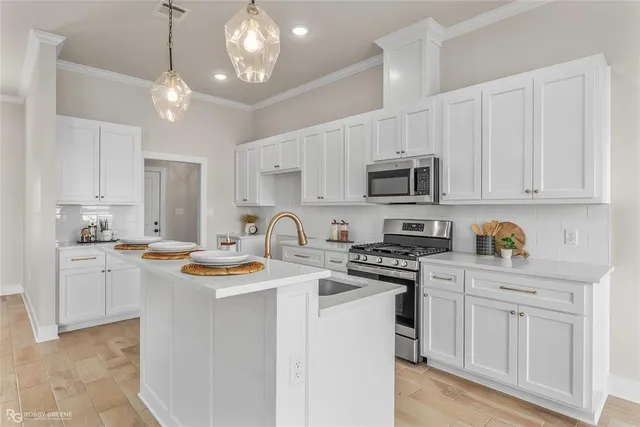 a kitchen with stainless steel appliances granite countertop a sink dishwasher a stove a microwave oven with white cabinets and wooden floor