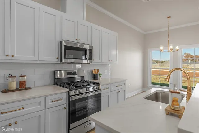 a kitchen with granite countertop a sink stainless steel appliances and cabinets