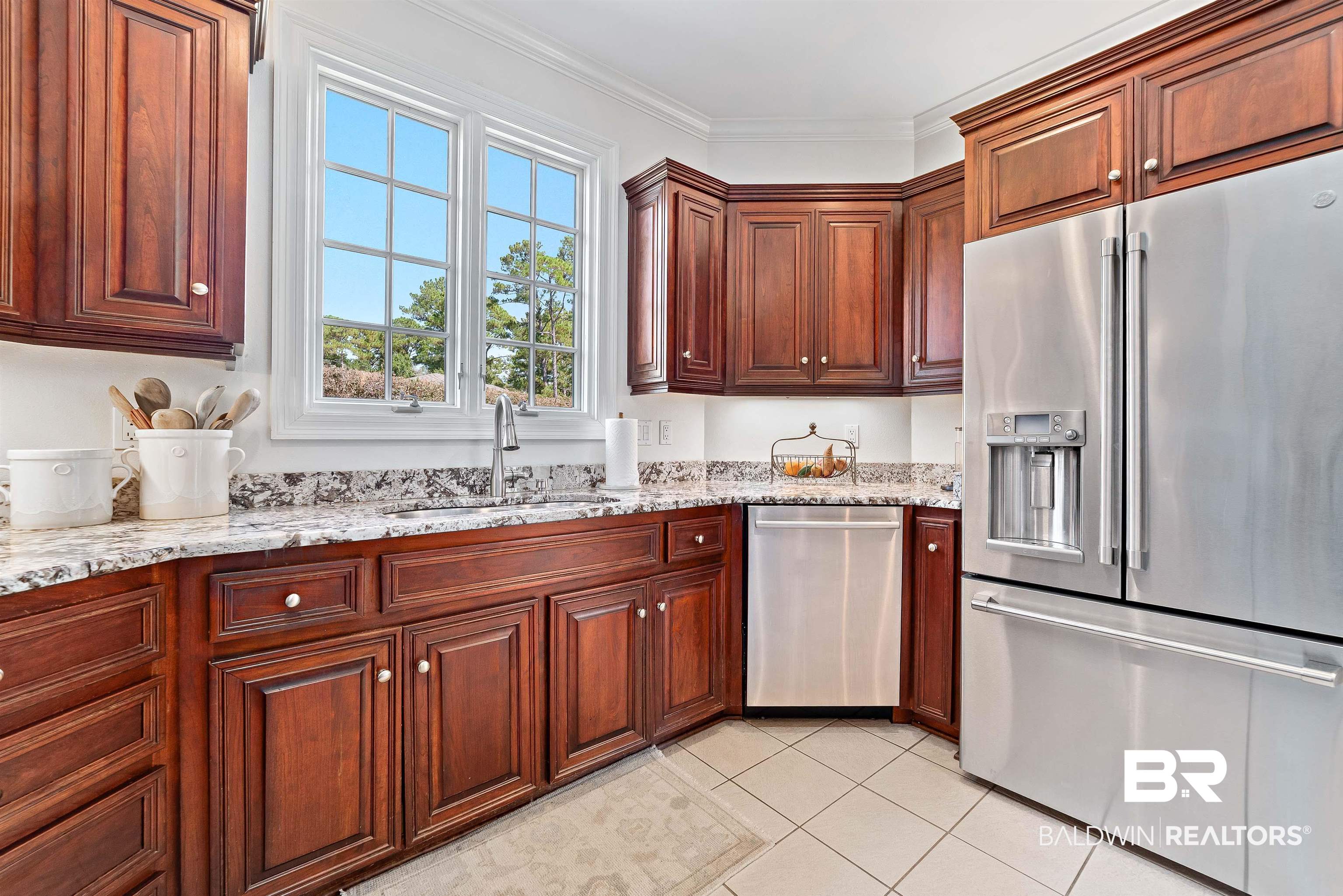6630 East Quarry Drive Elberta, AL 36530 - Photo 13 of 63 Kitchen with stainless steel appliances, light stone counters, light tile patterned flooring, and crown molding
