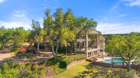 a aerial view of a house with a yard and large trees
