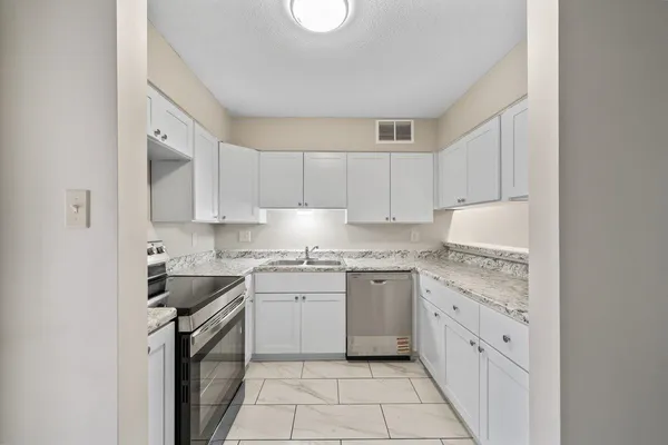 a kitchen with cabinets appliances a sink and a stove