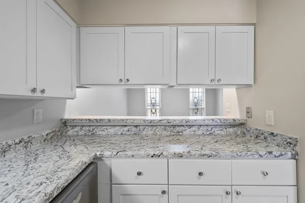 a view of granite countertop white cabinets and a granite counter top