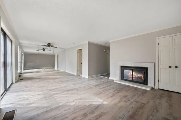 a view of an empty room with a fireplace and a window