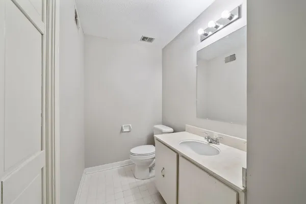 a bathroom with a toilet a sink and mirror