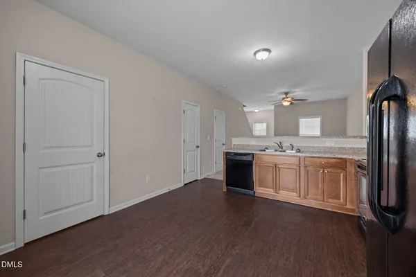 a large white kitchen with a sink dishwasher a stove and a refrigerator with wooden floor