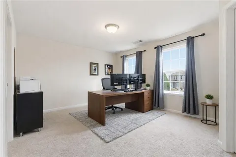 a view of a workspace with furniture and a window