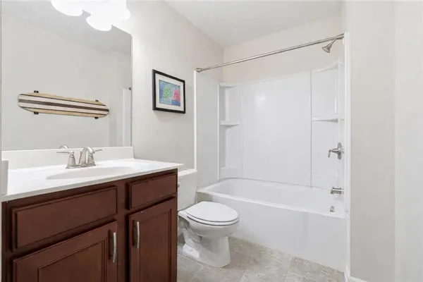 a bathroom with a toilet a sink a mirror and shower